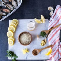 ingredients for the topping including a bowl of panko bread crumbs, garli, lemon zest, fresh herbs, seasoning and melted butter or oil