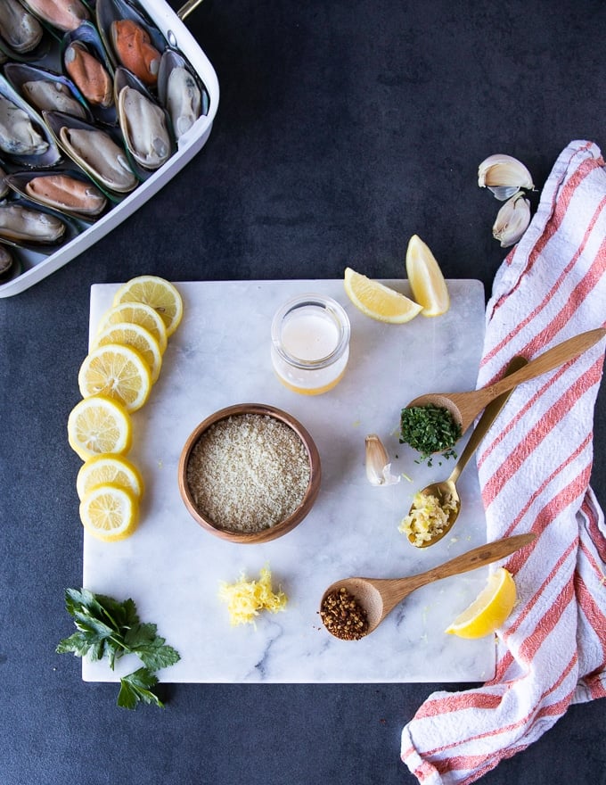 ingredients for the topping including a bowl of panko bread crumbs, garli, lemon zest, fresh herbs, seasoning and melted butter or oil