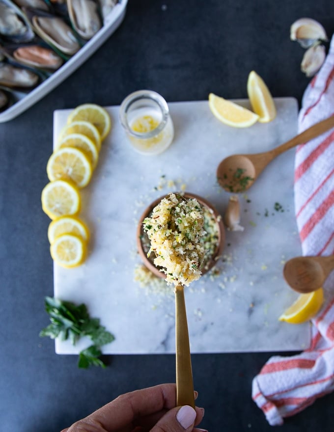 A spoon showing the texture of the final topping ready for the green mussels