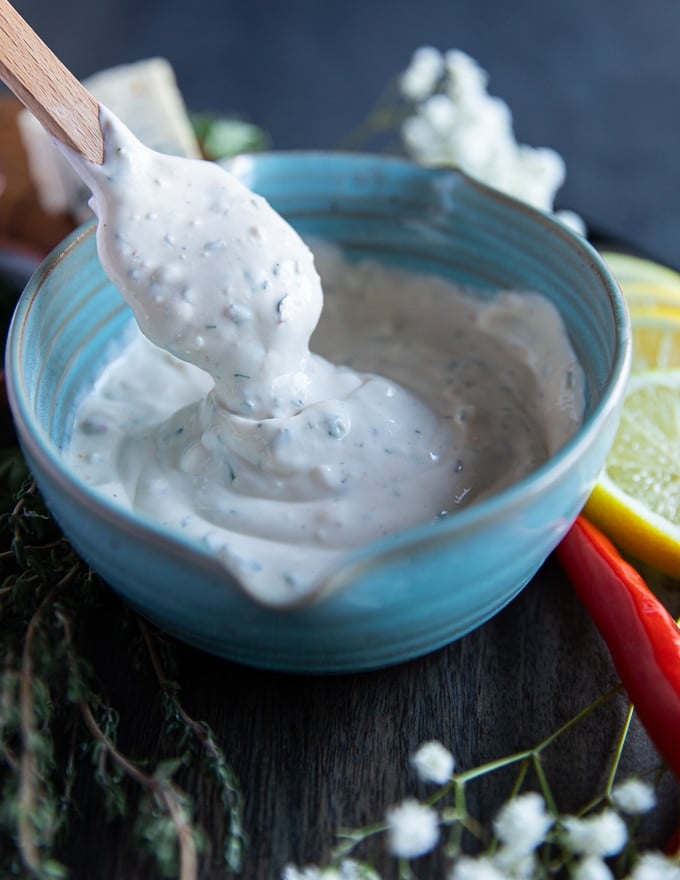 a bowl with a spatula holding up some blue cheese showing the thick twirl texture 