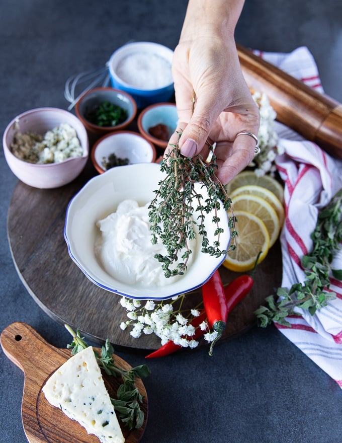 A hand holding fresh thyme leaves 