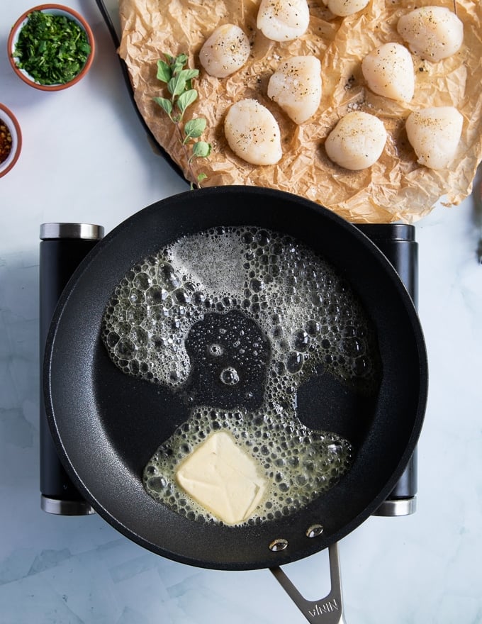 skillet preheating with lots of butter ready for pan seared scallops