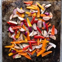 the marinated fajita veggies added to the same sheet pan and ready to cook