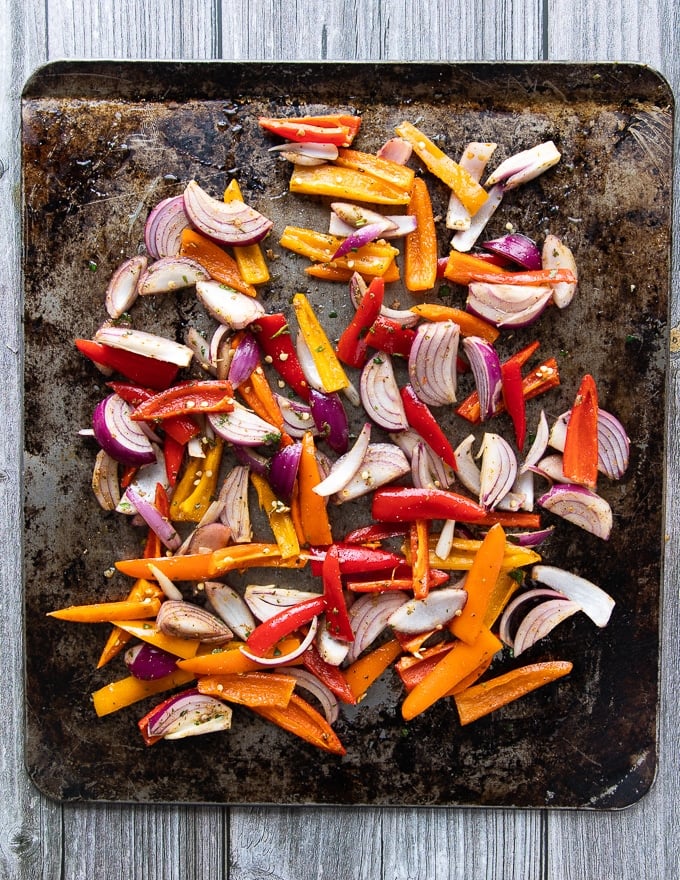 the marinated fajita veggies added to the same sheet pan and ready to cook 