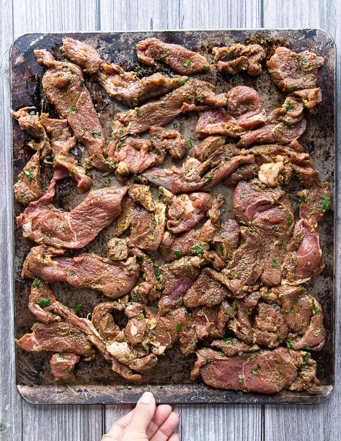 the meat spread in one single layer over a sheet pan and ready to broil 