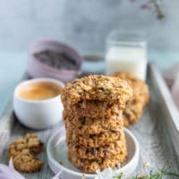 a stack of oatmeal cookies with a bitten cookie over the top showing the inside of the cookie