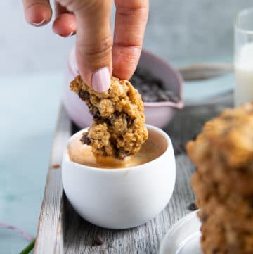 a hand dipping the oatmeal cookie recipe into a cup of espresso