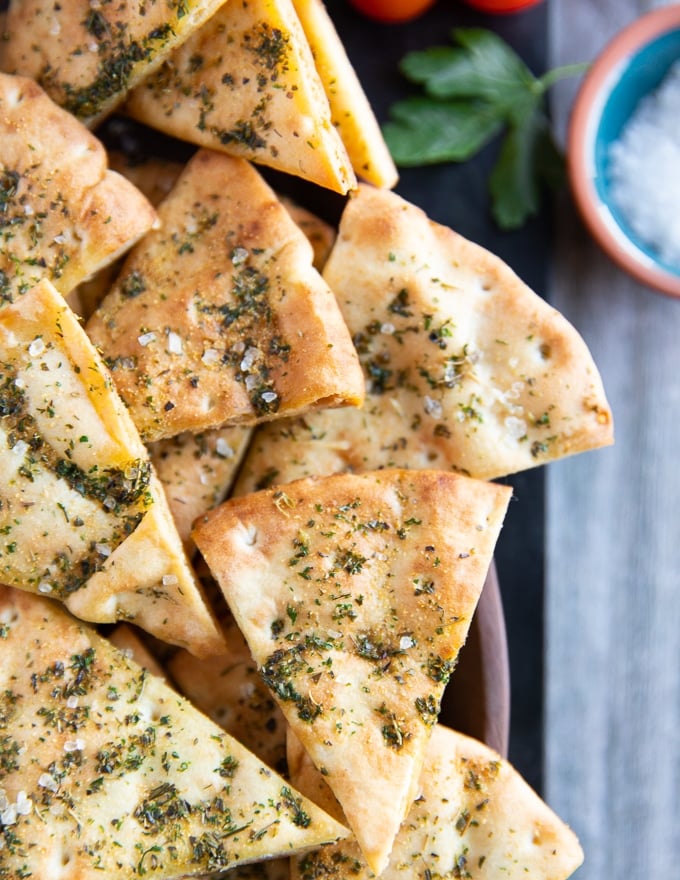 Some pita chips scattered on a plate showing the spice topping