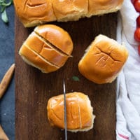 a knife slicing slits on the buns to make pizza rolls