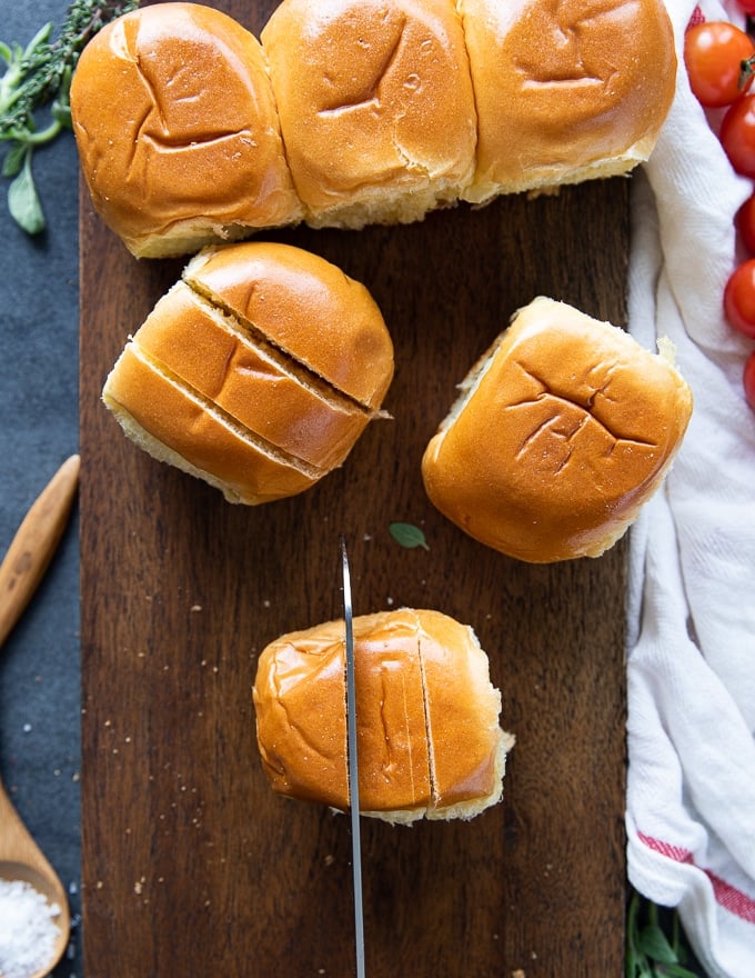 a knife slicing slits on the buns to make pizza rolls