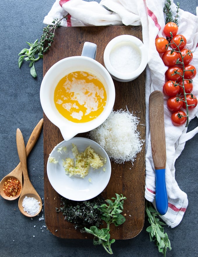 ingredients for the garlic butter inclusinf melted butter, garlic, parmesan cheese, fresh herbs and seasoning 