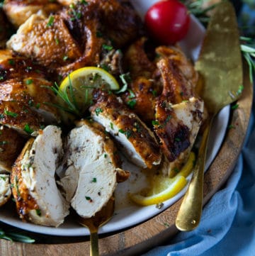 A fork holding a piece of air fryer whole chicken showing how juicy it is