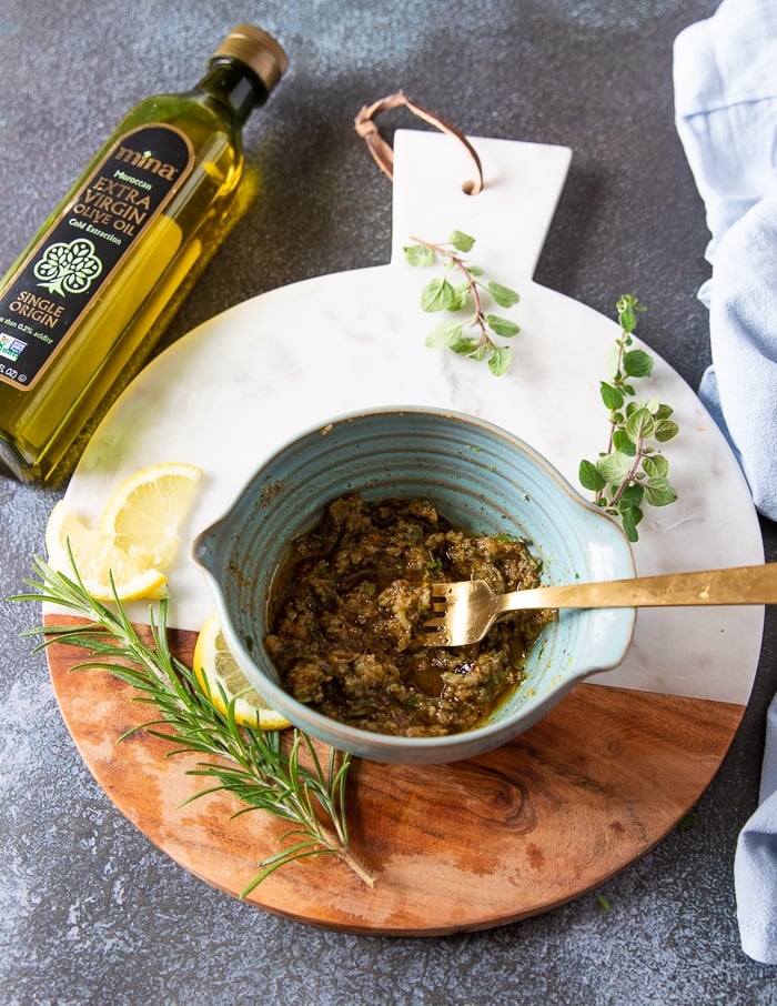 a bowl with the spice mixture and garlic and olive oil mixed in and ready for the chicken