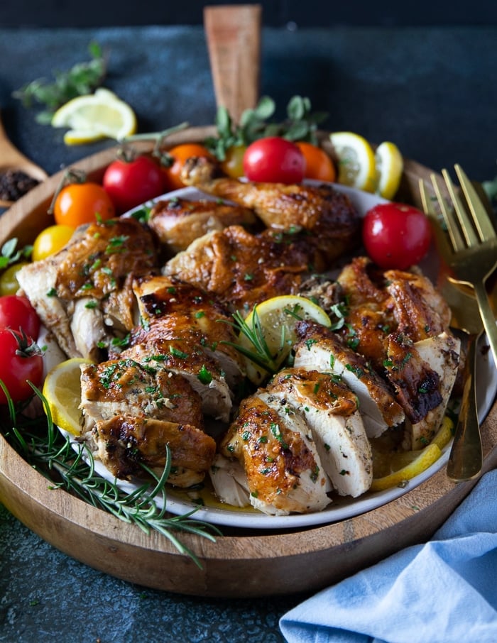 cutting up a whole chicken into pieces to serve on a plate