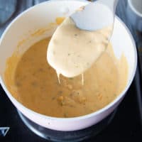 A spatula showing the final sauce in the pot ready