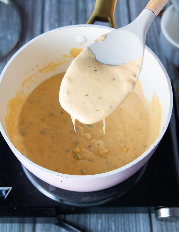 A spatula showing the final sauce in the pot ready