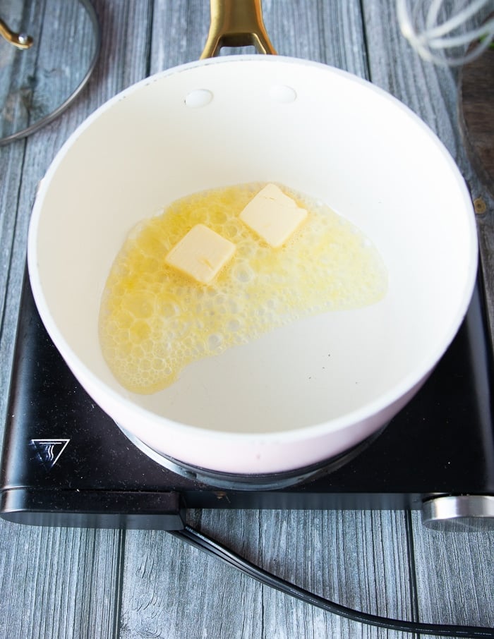 Se disuelve la mantequilla en una olla y se prepara la salsa de queso