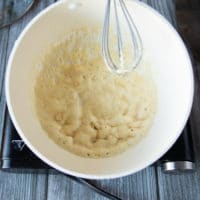 A whisk whisking in the flour into the butter to make the roux base of the sauce