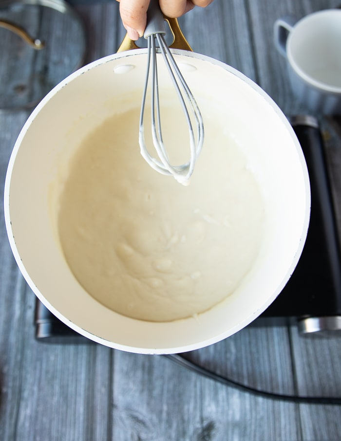 milk is added into the pot with the whisk