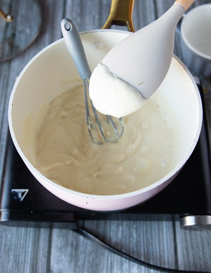 A spatula showing the final consistency of the rouch with. the milk boiled and the flour thickened