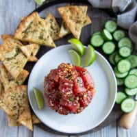 top view of tuna tartare recipe surrounded by pita chips, cucumber skices