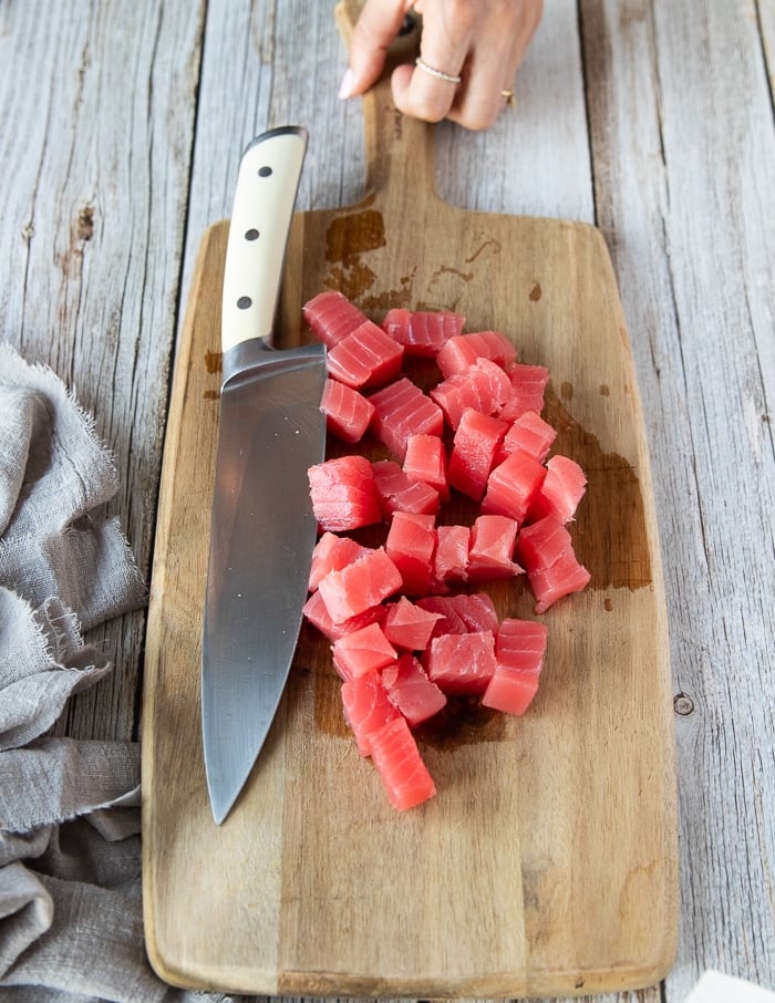 cut up chunks of fresh ahi tuna on a wooden board