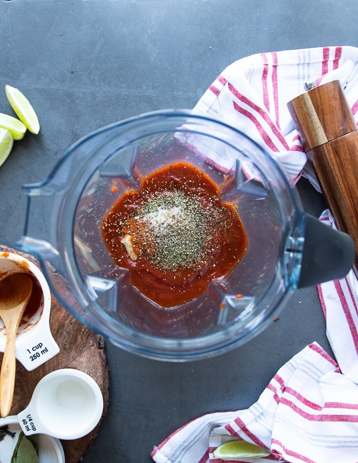 The remianing sauce ingredients are added into a blender including the chipotle, tomatoes, spiced and vinegar