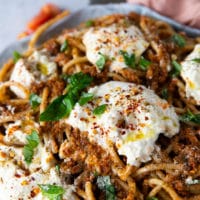 close up of the burrata cheese placed over the pasta and slightly warmed up and seeping into pasta