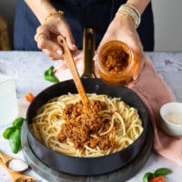 The cooked pasta drained and being tossed with sun dried tomato pesto