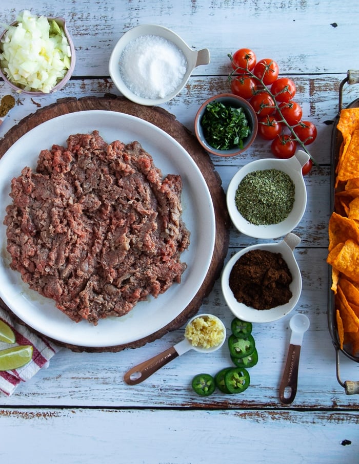 seasoned meat ingredients for the taco meat filling in the crunchwrap supreme including ground beef, onions, cilantro, onion, chiili ;powder, oregano, cumin, garlic, salt and pepper