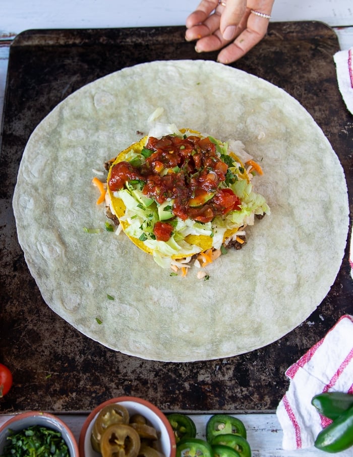 two spoonfuls of salsa layer added over to build the crunchwrap supreme