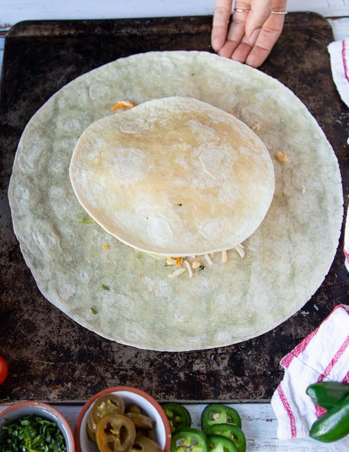 the final layer of the crunchwrap supreme is a small tortilla on the top and now the layers are complete
