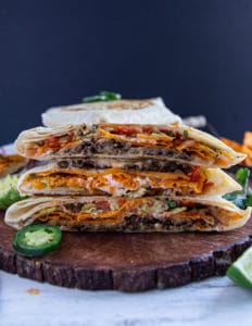 Piled up and stacked Crunchwrap supremes showing the layers and filling