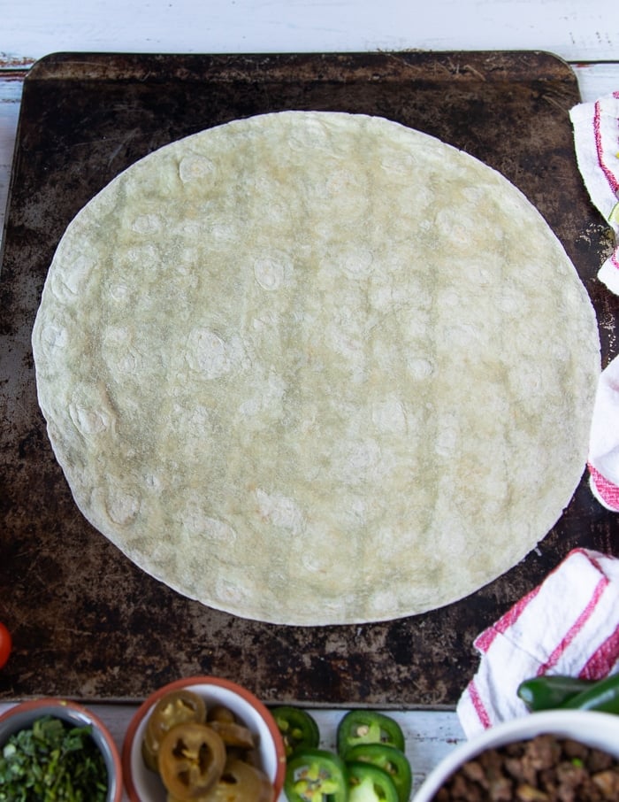 steps to making crunchwrap supreme starting with a large size tortilla at the bottom