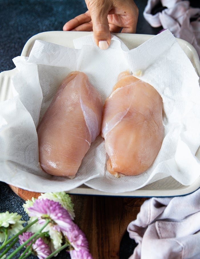 chicken breast after brining are place3d over a kitchen towel to pat dry before seasoning 