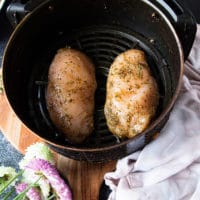 the chicken breasts placed in an air fryer basket and ready to cook