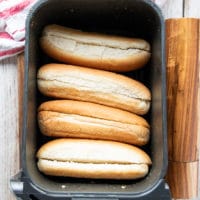 hot dog buns in an air fryer basket to taost
