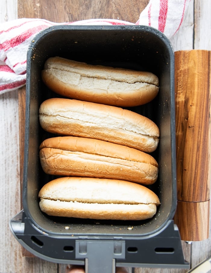 hot dog buns in an air fryer basket to taost