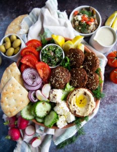 A close up of the falafel salad showing the ingr3edients arranged side by side and some olives on the side