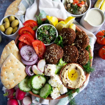 A close up of the falafel salad showing the ingr3edients arranged side by side and some olives on the side