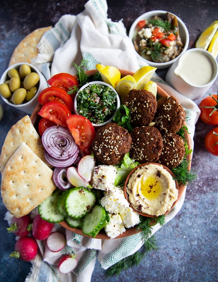 A close up of the falafel salad showing the ingr3edients arranged side by side and some olives on the side