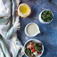 falafel bowl fixings such as tahini sauce, tabouleh, hummus dip and eggplant salad