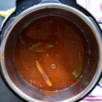 lamb birria stew cooking on medium heat until the meat is softened