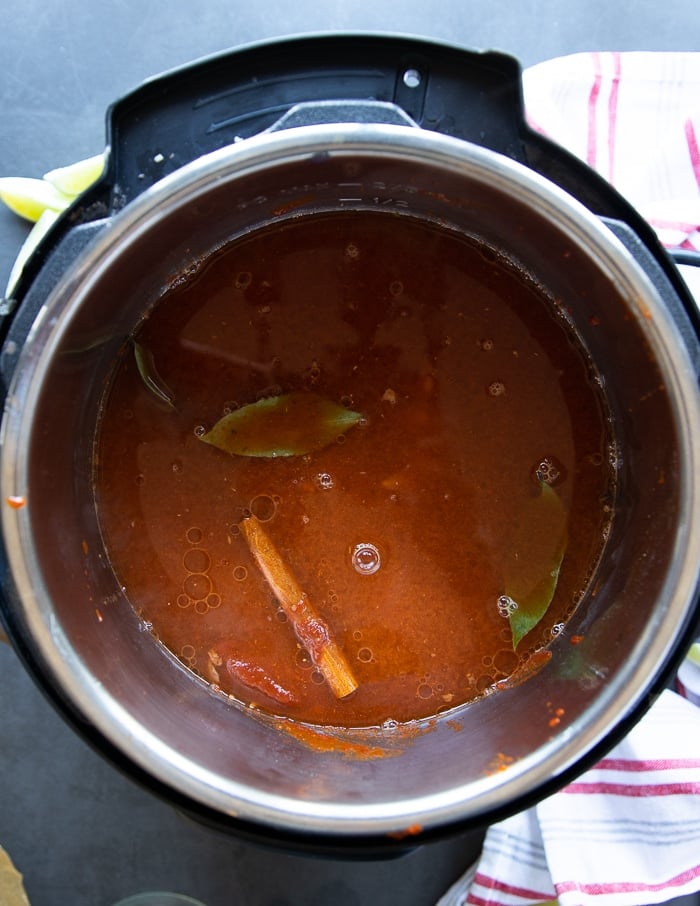 lamb birria stew cooking on medium heat until the meat is softened 