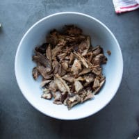 lamb meat tossed with some birria sauce in a large bowl