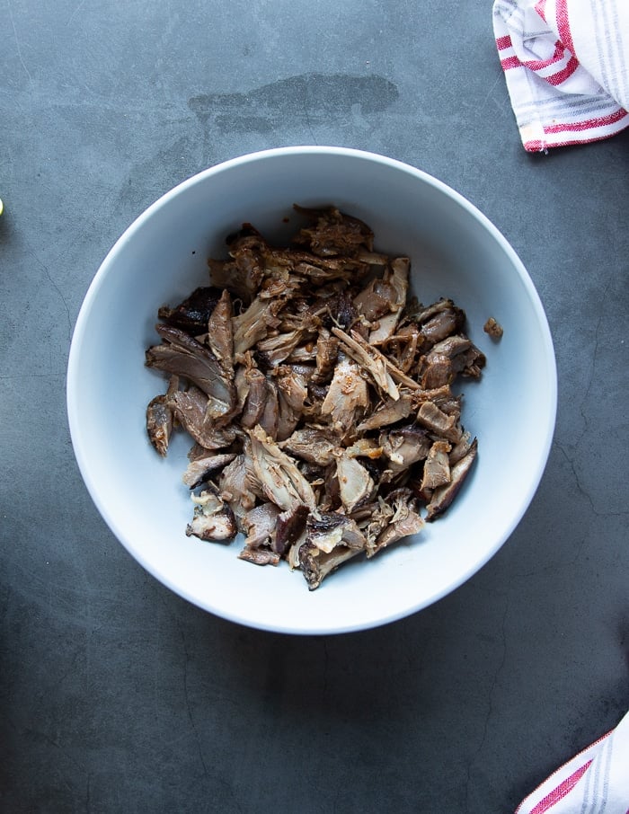 lamb meat tossed with some birria sauce in a large bowl