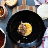 lamb meat and cheese go over the tortilla in the pan and then folded into a taco shape
