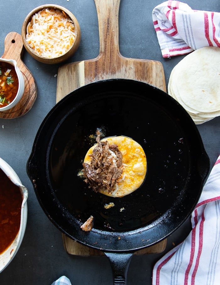 lamb meat and cheese go over the tortilla in the pan and then folded into a taco shape