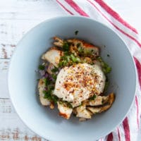 lobster and other lobster tail ingredients added into a large bowl including the mayo, celery, onions, celery, lemon juice and parsley