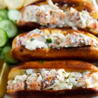 close up of a stack of lobster rolls showing the lobster roll filling and the toasted buns